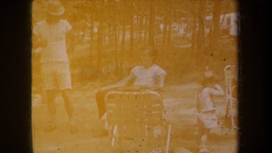 1968: countryside family picnic party, father sitting with his toddler. MICHIGAN