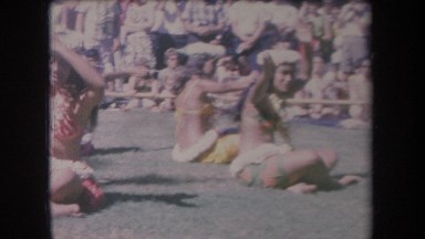 1969: native women in native dress sit on the grass and perform for a crowd
