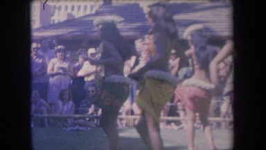 1969: women hula dancing in a circle in front of a crowd HAWAII