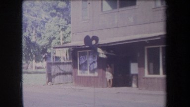1969: female standing outside a store as cars pass by HAWAII