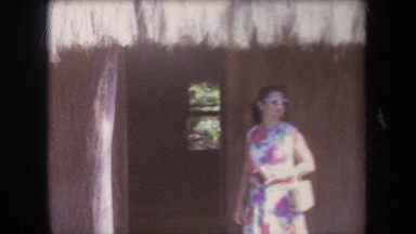 1969: woman in dress entering a hut HAWAII