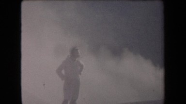 1958: Pueblo Style Buildings in Arid Desert with Men Walking Toward Them Arizona