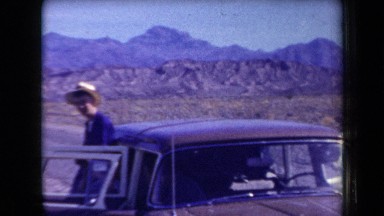 1958: some travelers by car stop to enjoy the scenery in a very arid area