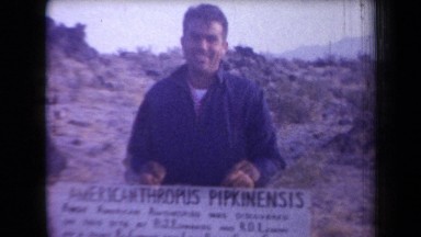 1958: a middle aged man jokingly shrugs and sticks his tongue out in front of a