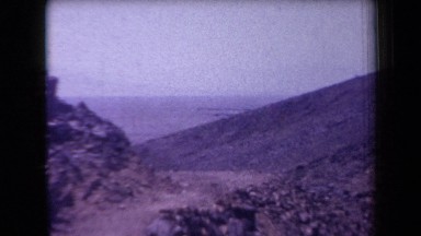 1958: desert environment with a dirt path near a rocky outcrop and people