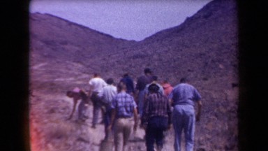 1958: A Small Group of Men and Women Follow a Trail Up a Shallow Hill in Arizona
