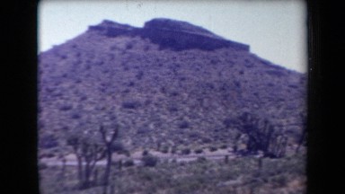 1958: desert panorama with a small hill and three cars parked ARIZONA