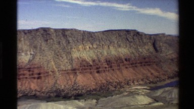 1980: Weathered Red Hills with a Big River in the Valley Below Western USA