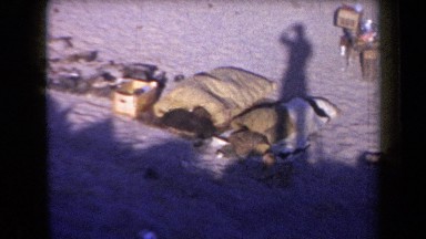 1958: Shadow of Person Recording Junkyard in Arizona