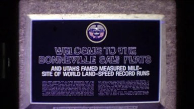 1980: Sign Welcome to the Bonneville Salt Flats; Trucks with Camping Trailers