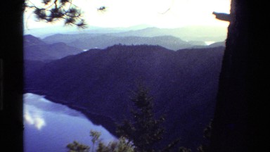 1980: Aerial of a Canyon with River Surrounded by Green Mountains and Exposed Peaks