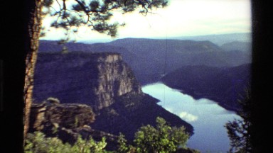 1980: lake surrounded by mountains and natural beauty is undisturbed on a sunny