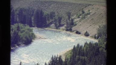 1980: a flowing stream moves through a tree-filled valley WESTERN USA