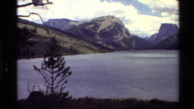1980: lake with rugged mountains in the background and a very lush lake shore