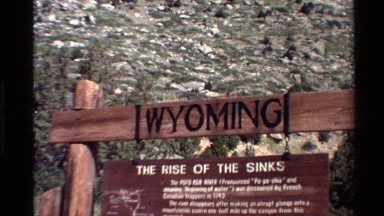 1980: a welcoming board made of wood with black and white letters WESTERN USA