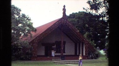 1981: a slow zooming clip of a building with an iconic figure at the apex of the