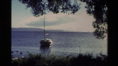 1981: A Lone Sailboat Sits Idle in the Water Near the Shore, New Zealand