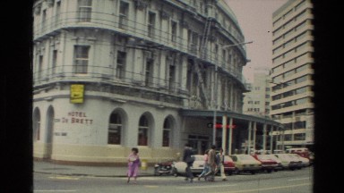 1981: people crossing the streets in a busy office buildings setting.