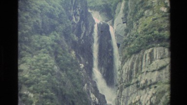 1982: tall waterfall flowing down a narrow drop between granite rock NEW ZEALAND