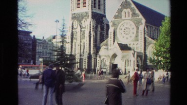 1982: a church with a very large tower and people passing in front of it NEW