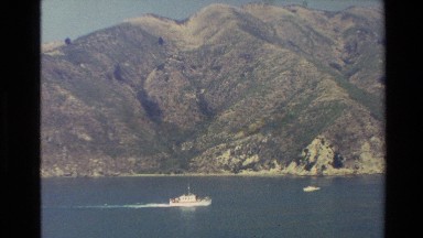 1982: cut clips of different mountain ranges surrounding a body of water during