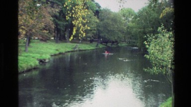 1982: two children rowing down a small scenic river NEW ZEALAND