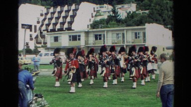1982: Scottish Bagpipers in Kilts Marching on a Field in New Zealand