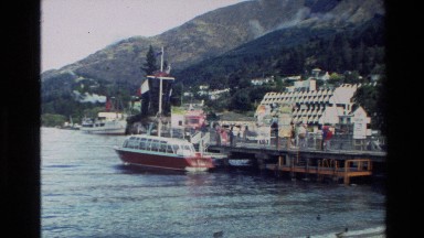 1982: marina within a cove or bay with boats moored, surrounded by mountains