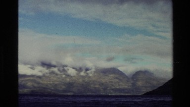 1982: mountains with clouds surrounding them over a lake NEW ZEALAND