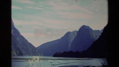 1982: overview of a set of mountains at the edge of a lake on a clear day NEW