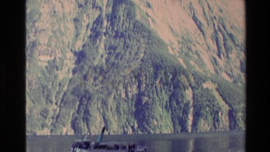 1982: boats moving through the waters of the lake in the valley of huge mountain