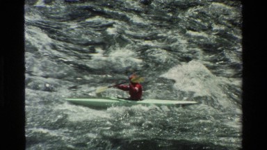 1980: a man in red dress and a cap is moving in a boat in sea GRAND TETON