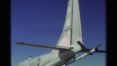 1981: different angles of airplane sitting on runway while people walk about