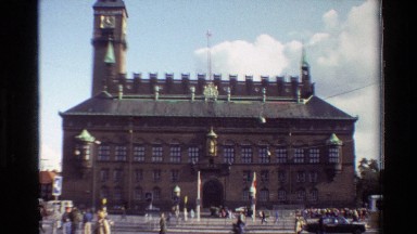 1982: Four-Story Brick Building with Steeple in Busy Danish Square