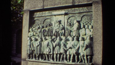 1982: Stone Carving on Wall Showing a King Sitting on His Throne Surrounded by Warriors