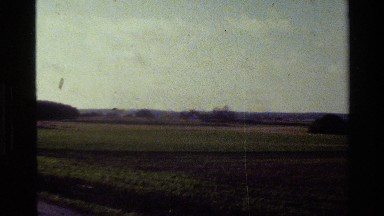 1982: panorama of a countryside with a few homes, barns and plowed fields