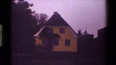 1983: an iron fence and gate with lion statues atop stone pillars surrounds a