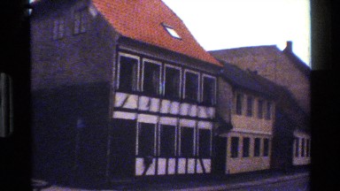 1983: lone pedestrian on sidewalk is across quaint buildings with dark windows