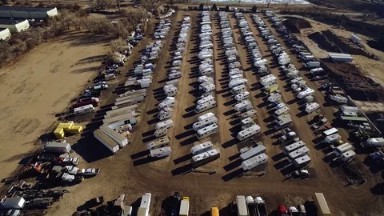 Aerial of RVs Parked in an Open Flat Area by a River COLORADO
