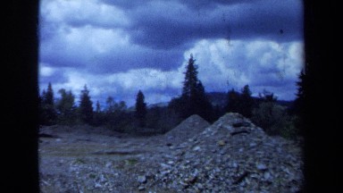 1971: dozer with piles of rocks in a valley MAINE