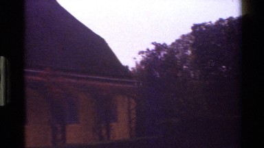 1983: Woman Stands and Looks at House with Mansard Roof, Short Pipes