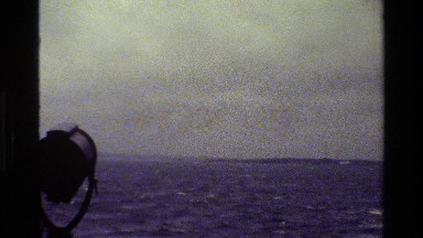 1983: a large black and white cruise ship is sailing on rocky waters DENMARK