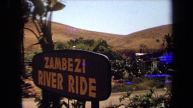 1971: sign: zambezi river ride; tourists in a covered tour boat LAGUNA HILLS