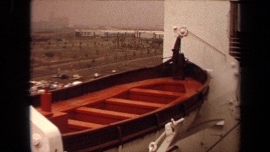 1971: view of emergency evacuation boat on side of a larger ship LONG BEACH