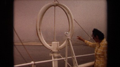 1971: man reaches out towards the ocean while standing on the upper level