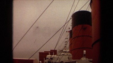 1971: the exhaust funnels of a large ship line the deck while a rope line behind