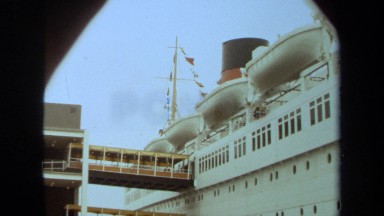 1971: a large cruise ship ready for boarding with gangways connected