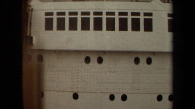 1971: the side of a large passenger cruise ship, including a large lifeboat