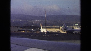 1970: runway full of airplanes ready to be boarded as a cart transports luggage