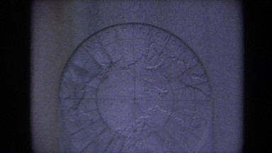 1970: a map on a stone, zooming in to reveal that the map is centered